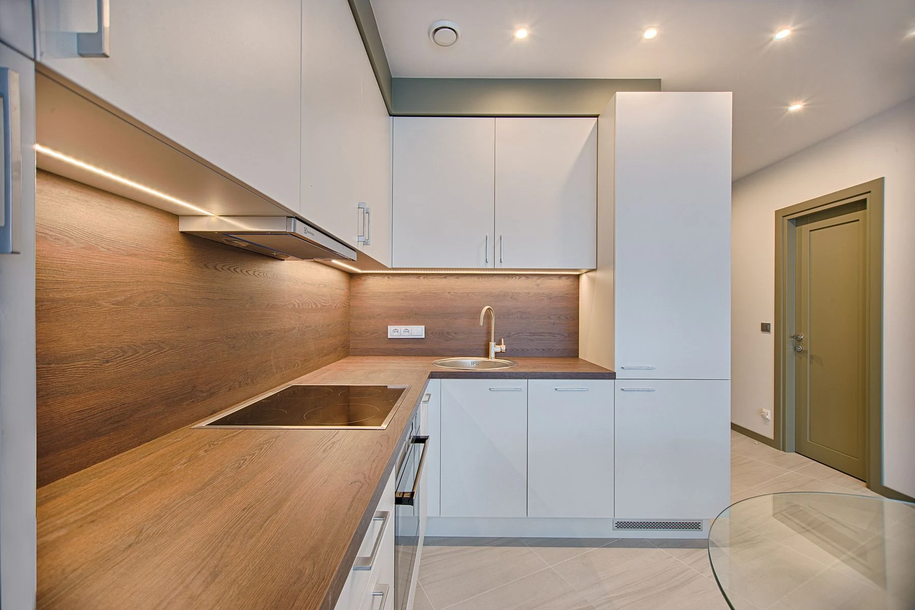 Modern kitchen interior with minimalistic design and wooden accents, captured with natural lighting. Reference photograph for Nocturne House.