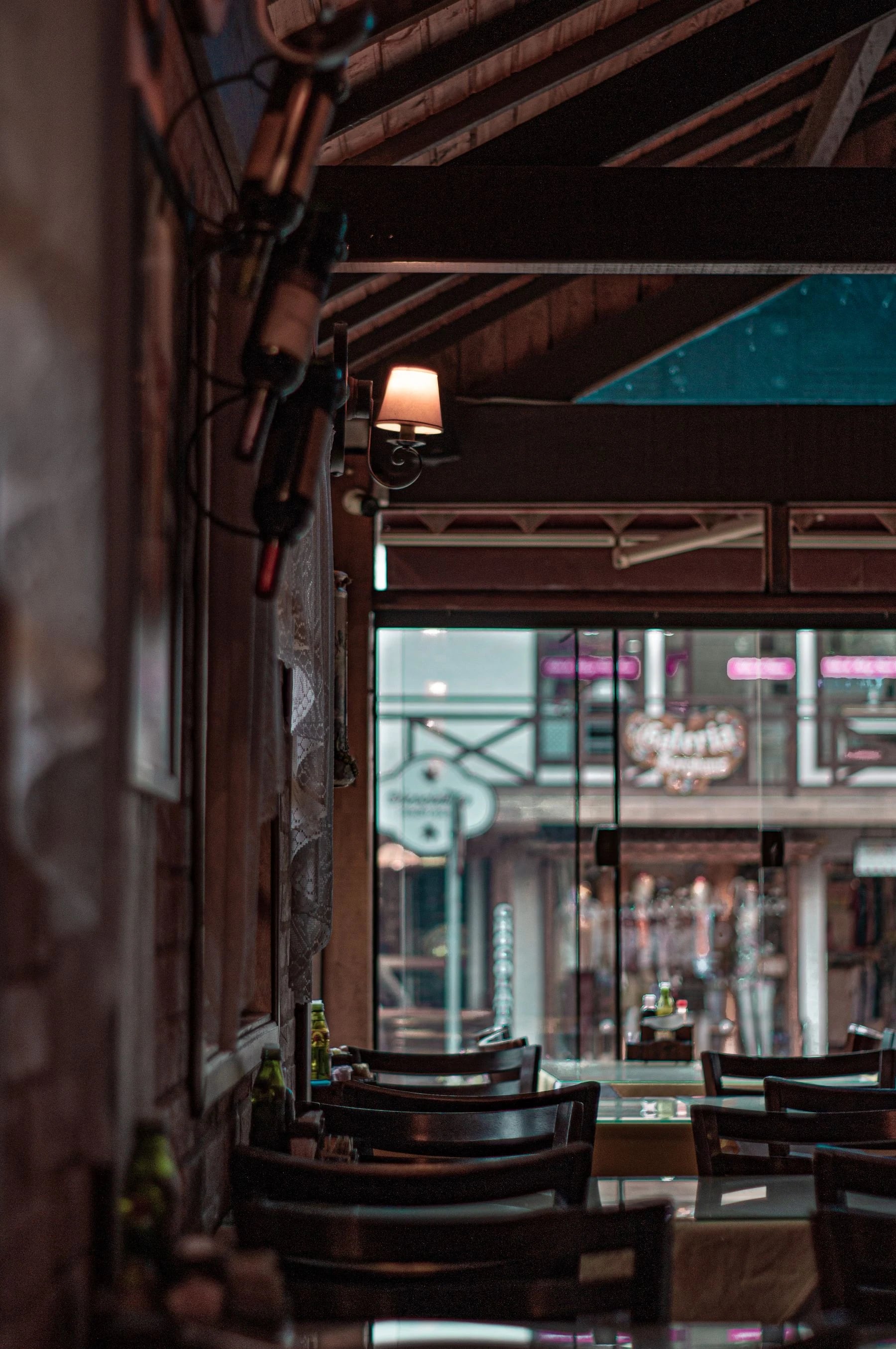 Warm, inviting restaurant interior with rustic charm and wine bottles on display. Reference photograph for Forme Workspace.