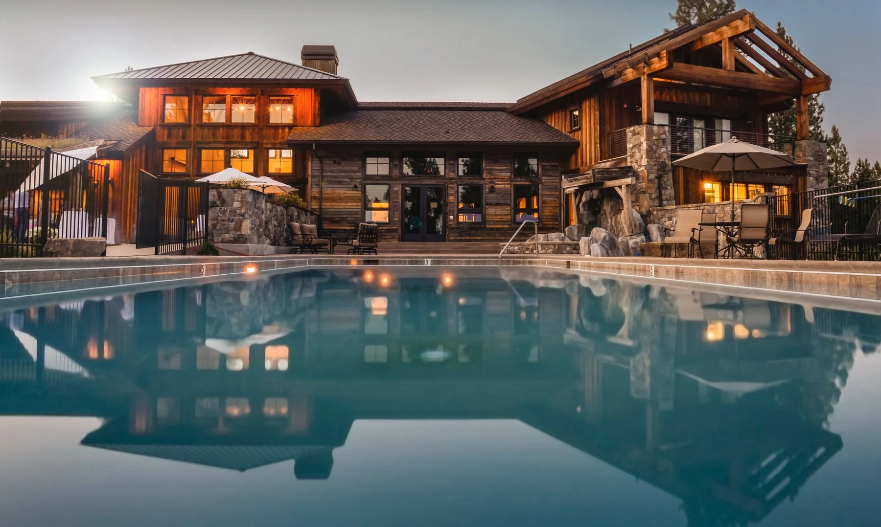 Wooden villa with a large pool and cozy lights, perfect for a luxurious escape. Reference photograph for The Avara Villa.