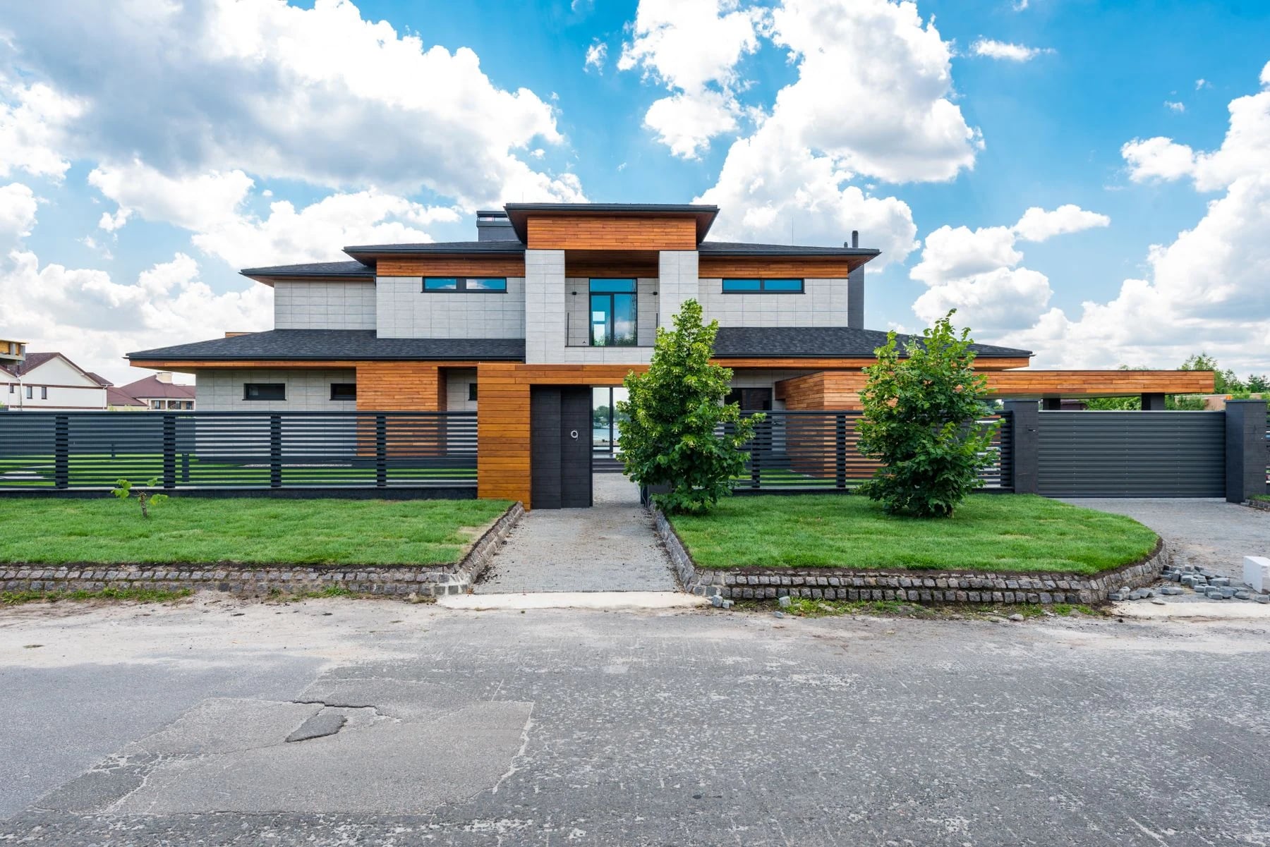 Modern luxury home exterior with sleek architecture and lush greenery. Reference photograph for Sela Residence.