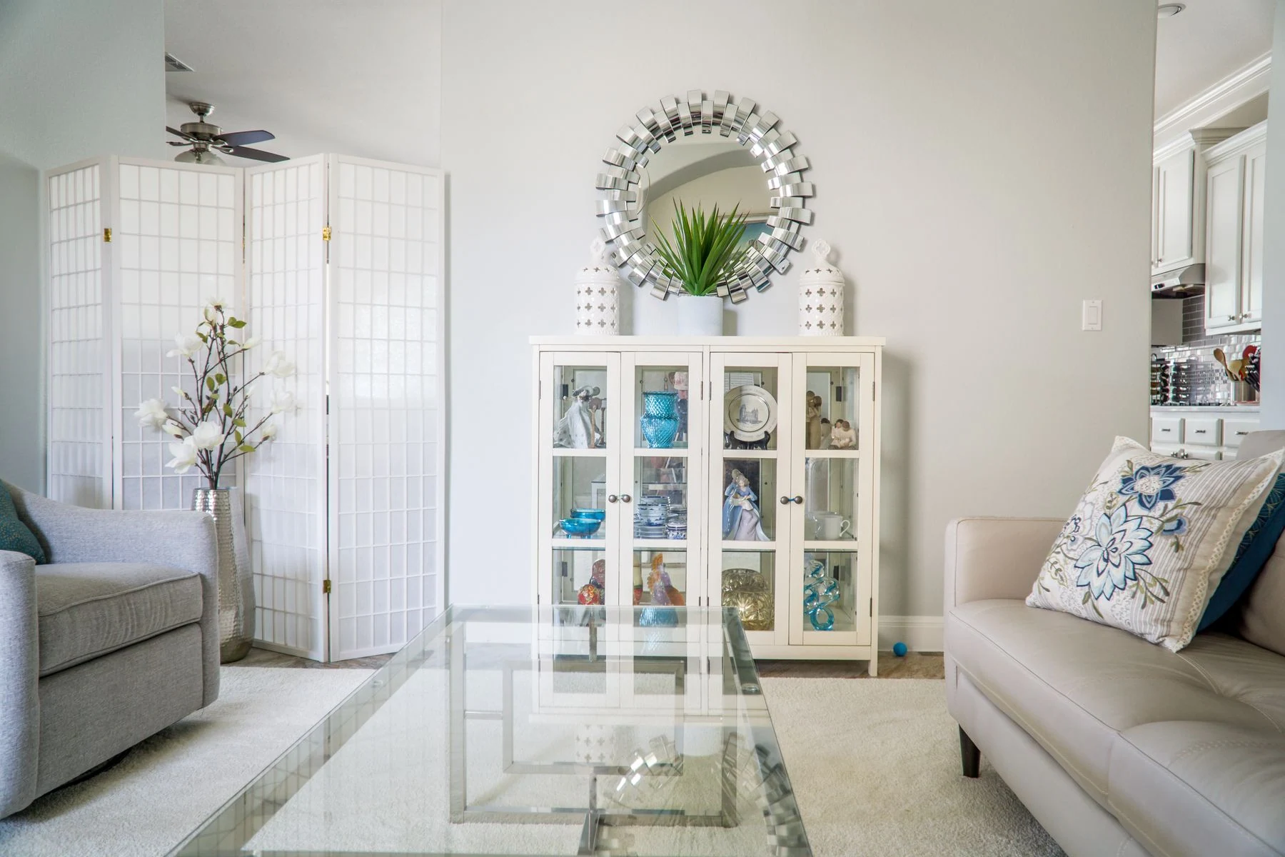 Bright living room with modern decor, featuring a glass table, plush sofas, and decorative elements in Austin, TX. Reference photograph for The Luma House.