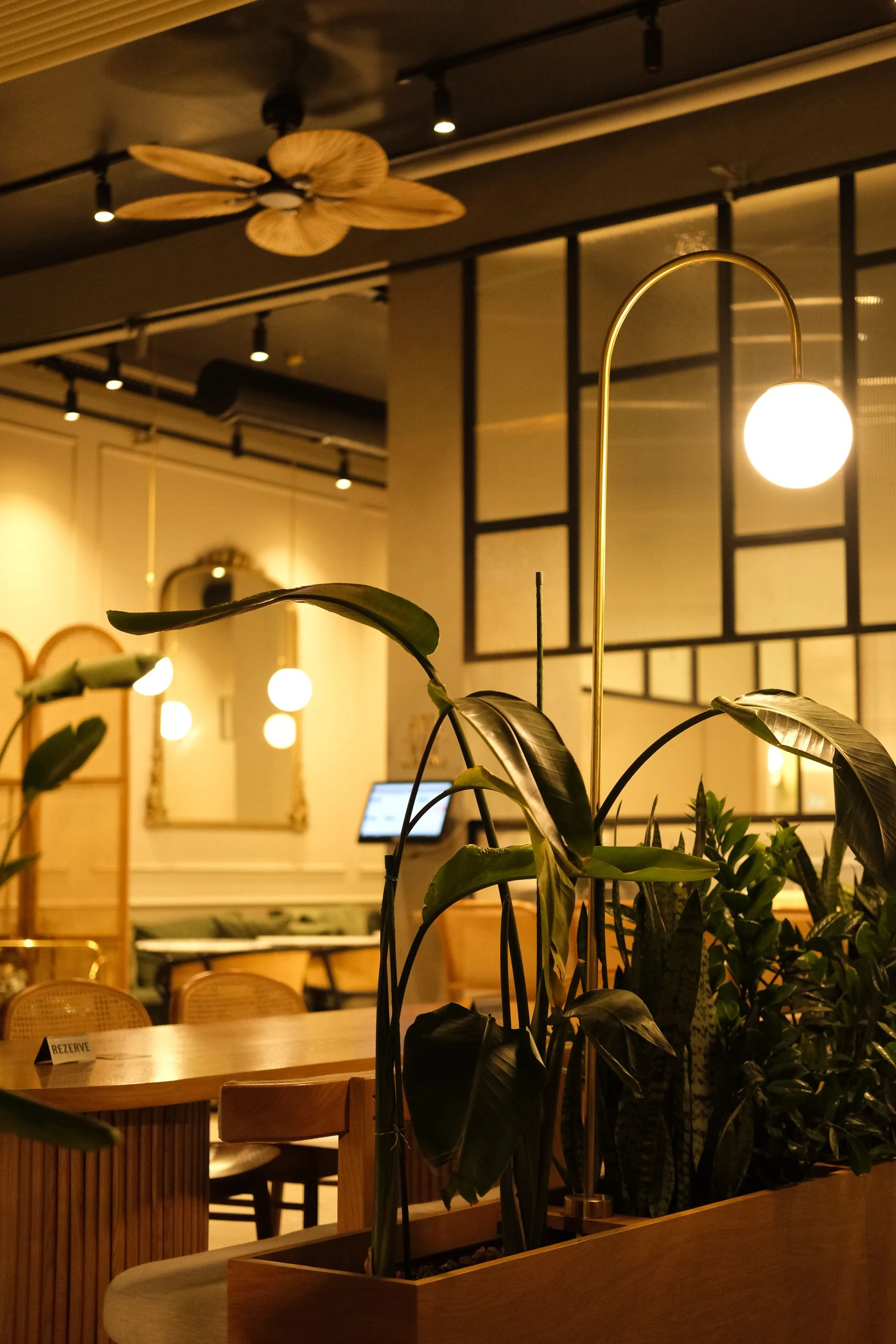 Cozy restaurant interior featuring plants and modern lighting creating a warm ambiance. Reference photograph for Forme Workspace.