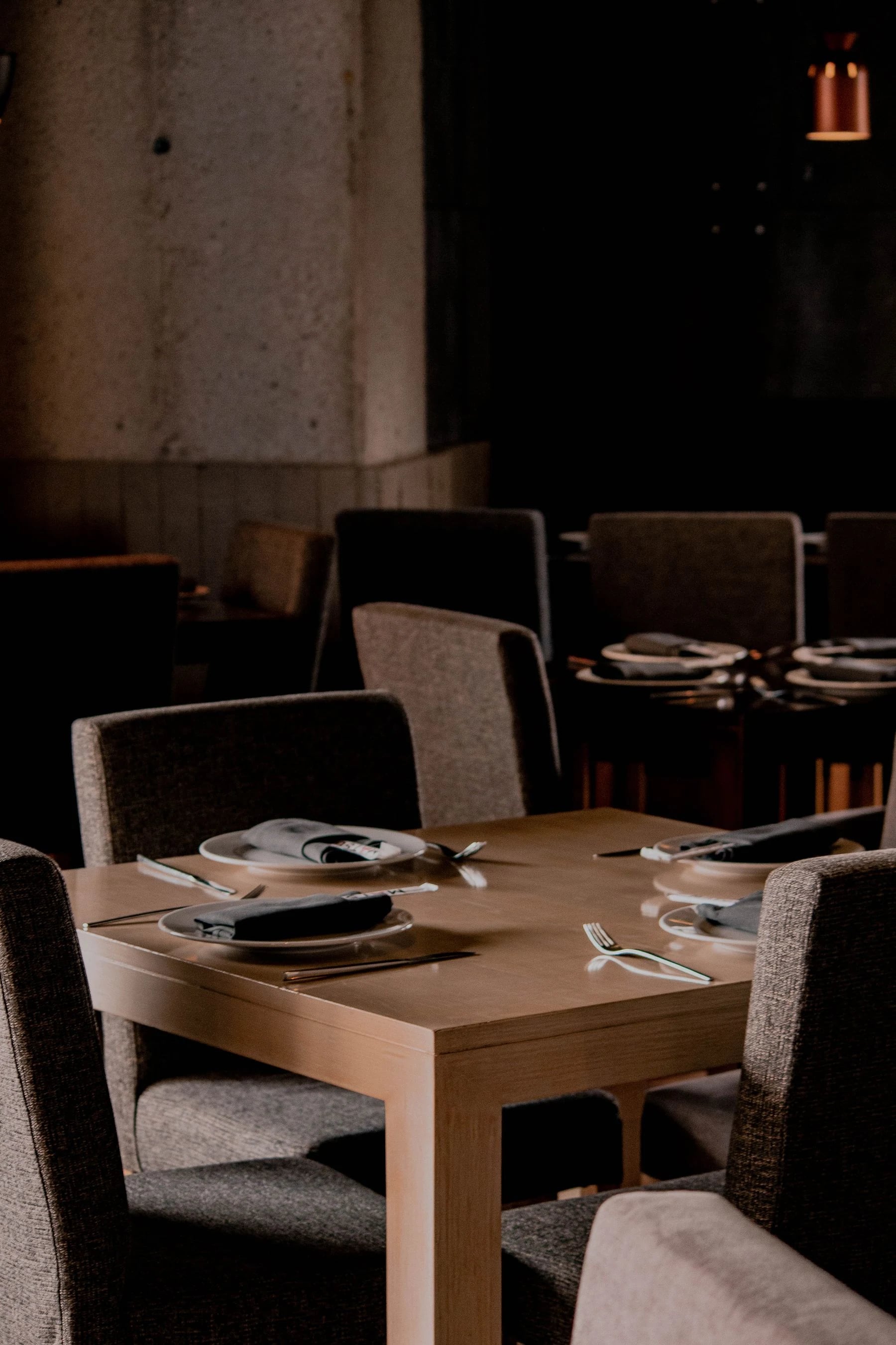Chic restaurant setting with modern decor, chairs, and a beautifully set table ready for dining. Reference photograph for Forme Workspace.